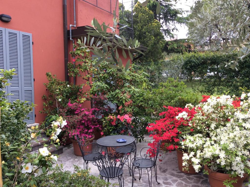 a patio with flowers and a table and chairs at B&B La Dimora Del Garda in Sirmione