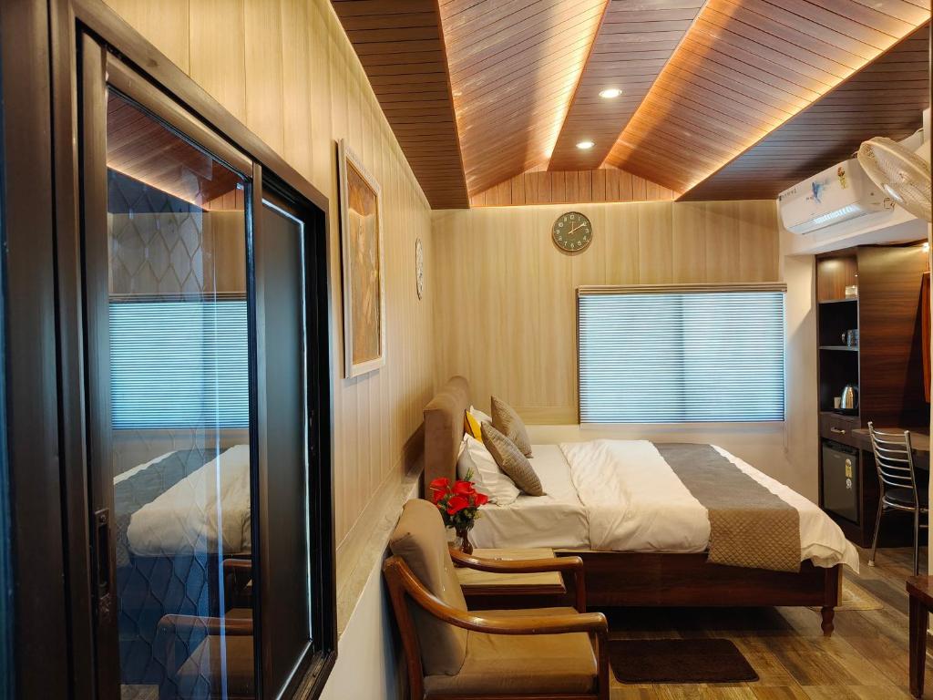 a small room with a bed and a chair in it at Eastern Gate Homestay in Khajurāho