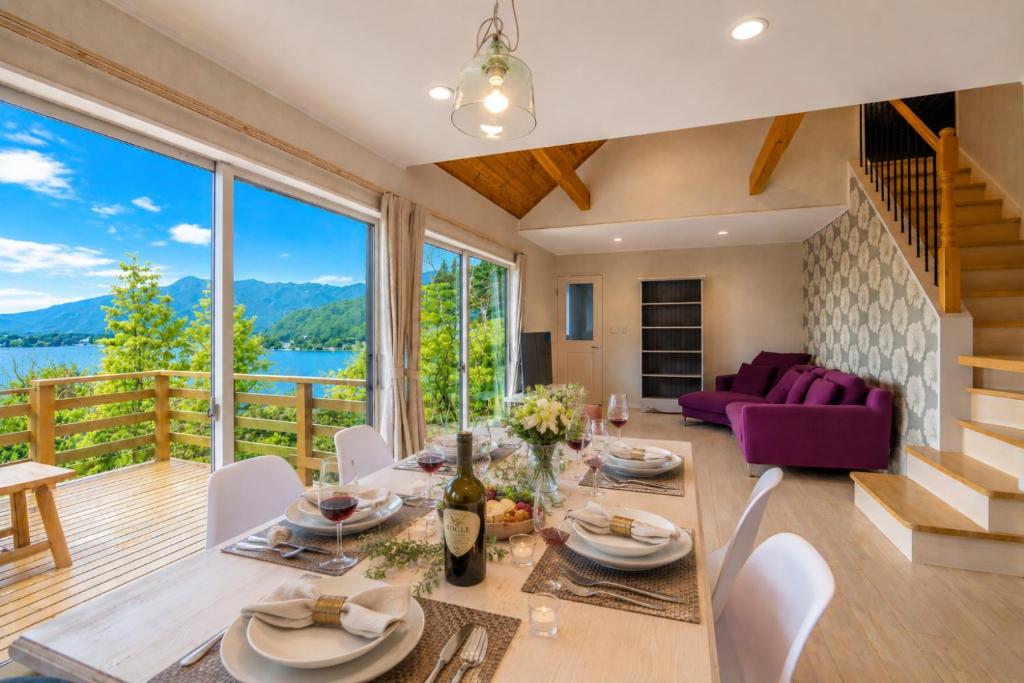 a dining room with a table and chairs and a large window at tocoro. Mt. Fuji Mutsuki in Fujikawaguchiko