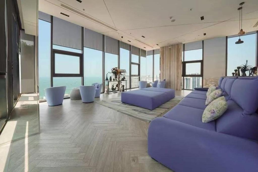 a living room with purple furniture and large windows at The Base Pattaya Seaview Condo in Pattaya