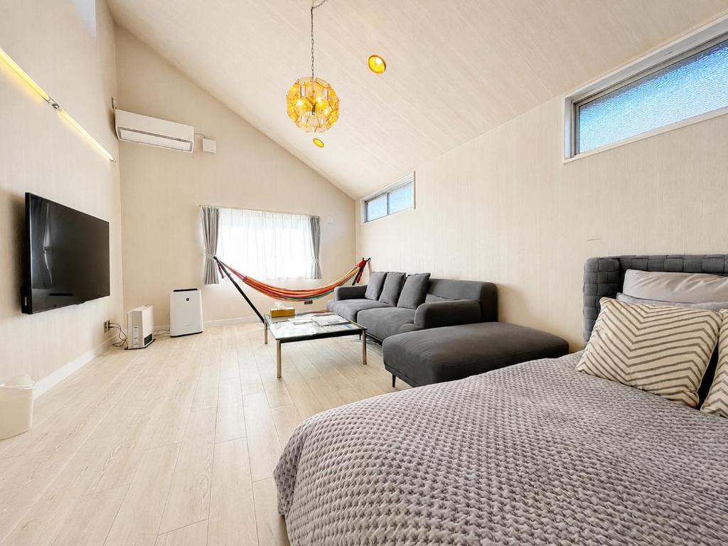 a bedroom with a bed and a couch and a tv at tocoro. Mt. Fuji Hazuki in Fujikawaguchiko