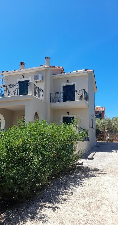 a white house with a balcony on top of it at Βίλλα Αντρέας in Karavomylos
