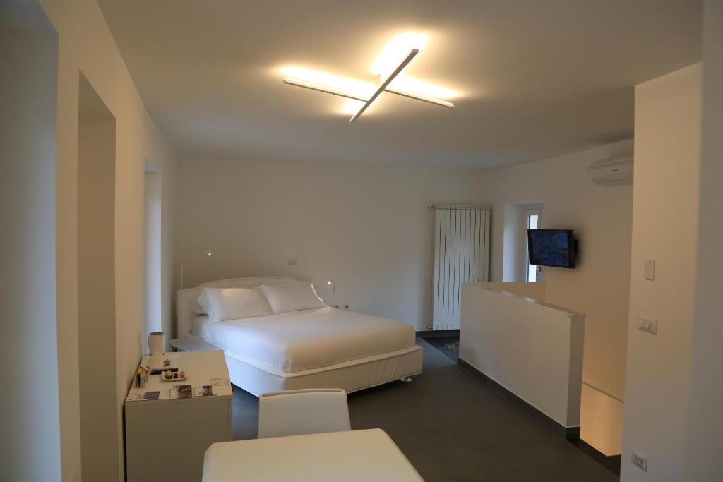 1 dormitorio con 1 cama y ventilador de techo en Duo Rooms en Mondovì