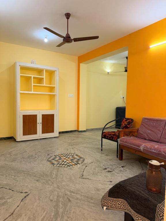 a living room with yellow walls and a couch at Villa Yogalakshmi in Chidambaram