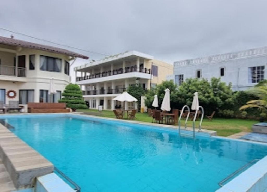 a large swimming pool in front of a hotel at Cozzy Seaview Beach Resort in Jepara