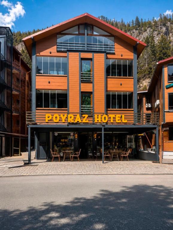 a resort building with tables and chairs in front of it at Poyraz Hotel Uzungöl in Uzungöl