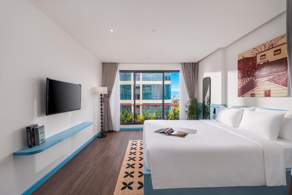 a hotel room with a bed and a tv at The Locals Hotel - Dinh Thi Hoa Da Nang in Danang