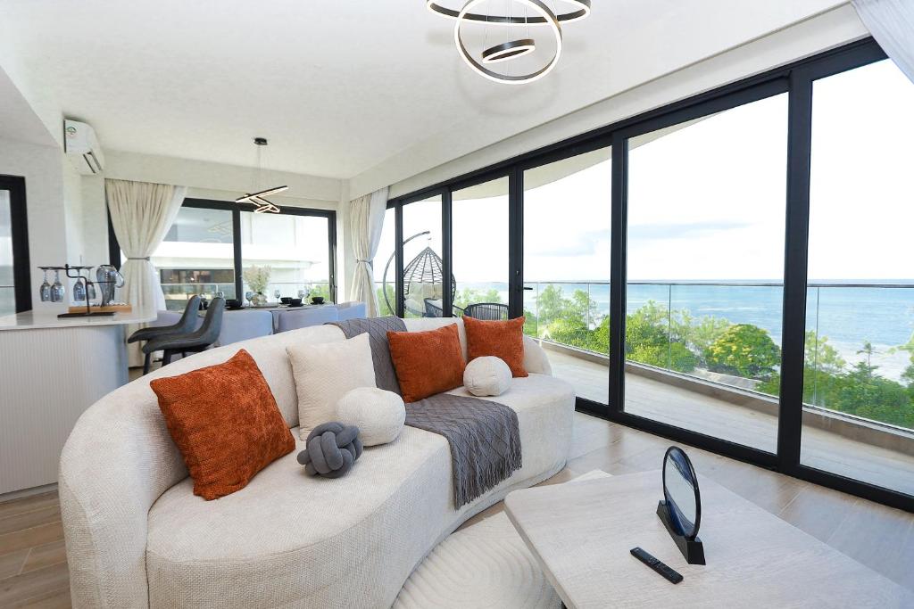 a living room with a white couch and large windows at Diane Homes Evoque nyali in Mombasa