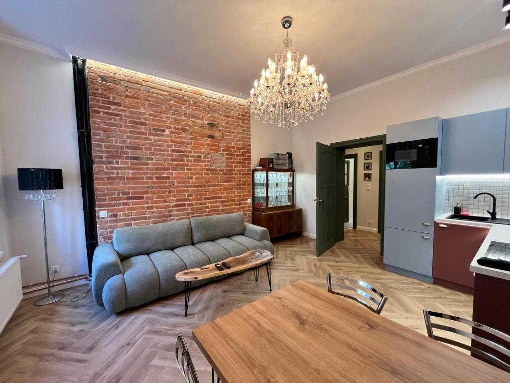 a living room with a couch and a brick wall at Brick and Wood Apartments in Bydgoszcz