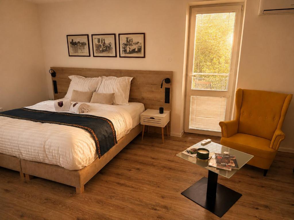 a bedroom with a bed and a chair and a table at Boutique Hotel at Golf Piestany in Piešťany