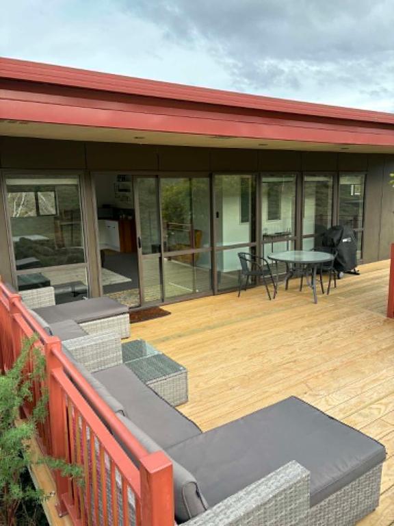a patio with a table and chairs on a deck at Clydesvale Apartment in Clyde