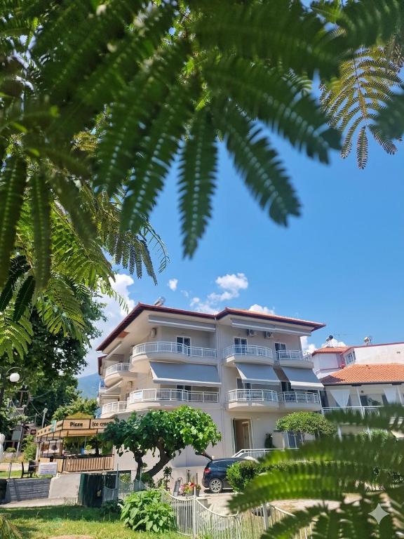 a large white building with a palm tree at VILLA KETI in Leptokarya