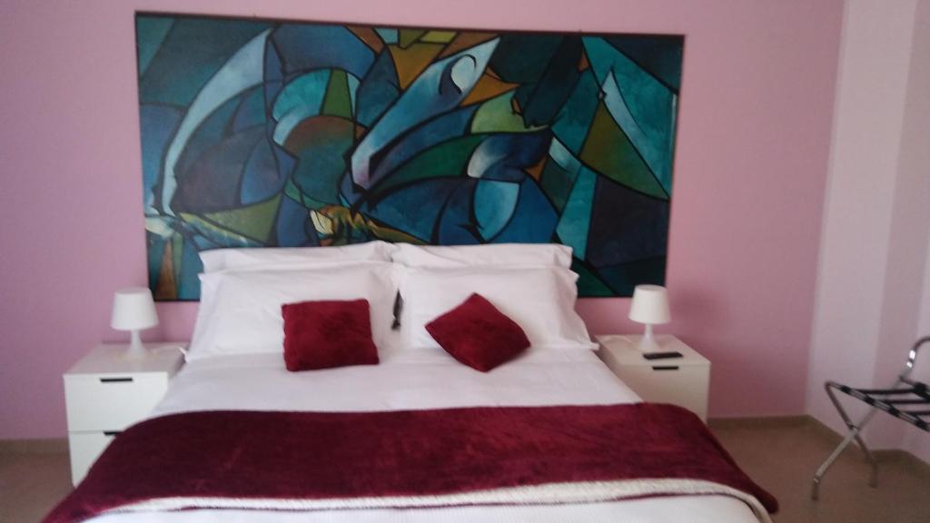 a bedroom with a large bed with two red pillows at B&b Bagheria in Bagheria