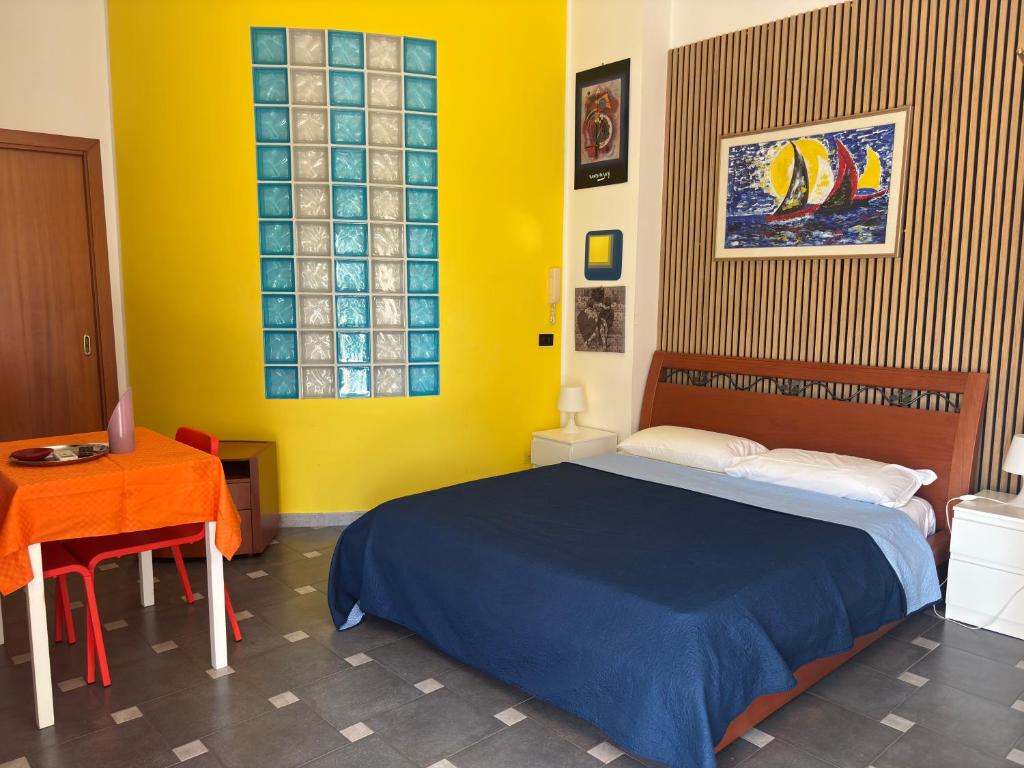 a bedroom with a blue bed and a table at La rosa di Rebecca in Monopoli