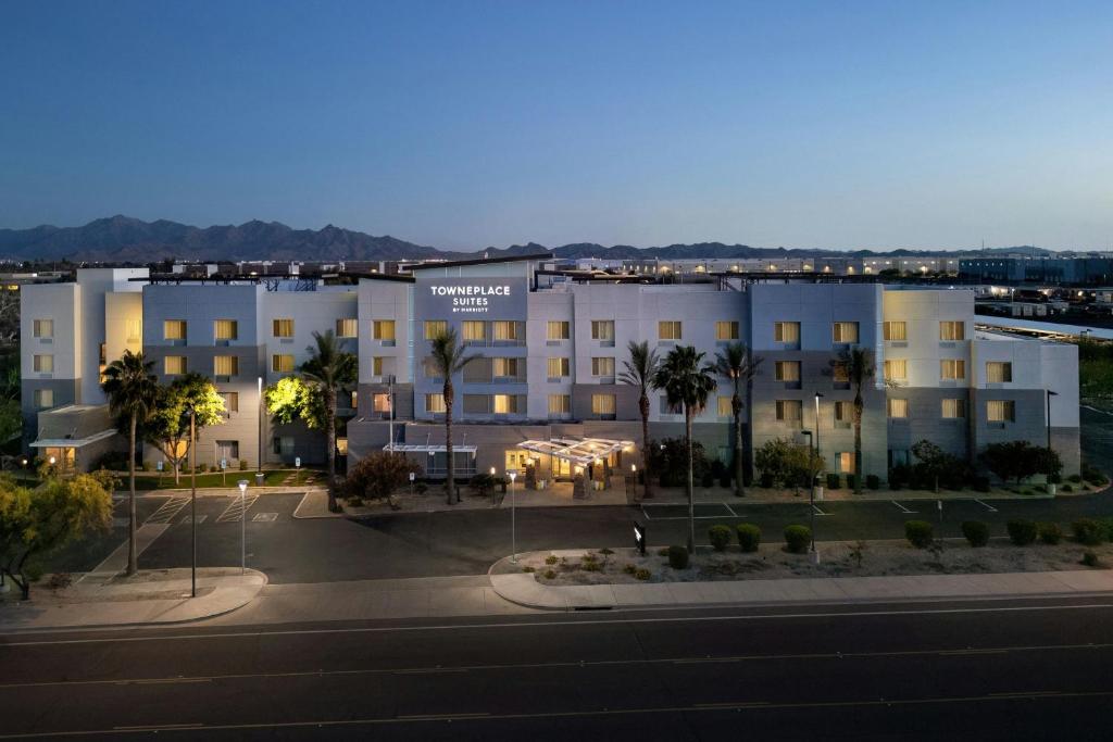 a large white building with palm trees in front of it at TownePlace Suites by Marriott Phoenix Goodyear in Goodyear