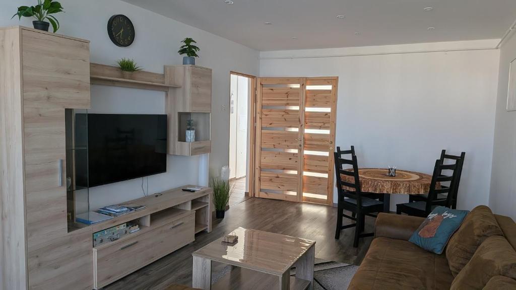 a living room with a couch and a tv and a table at Magaslak Apartman in Kaposvár