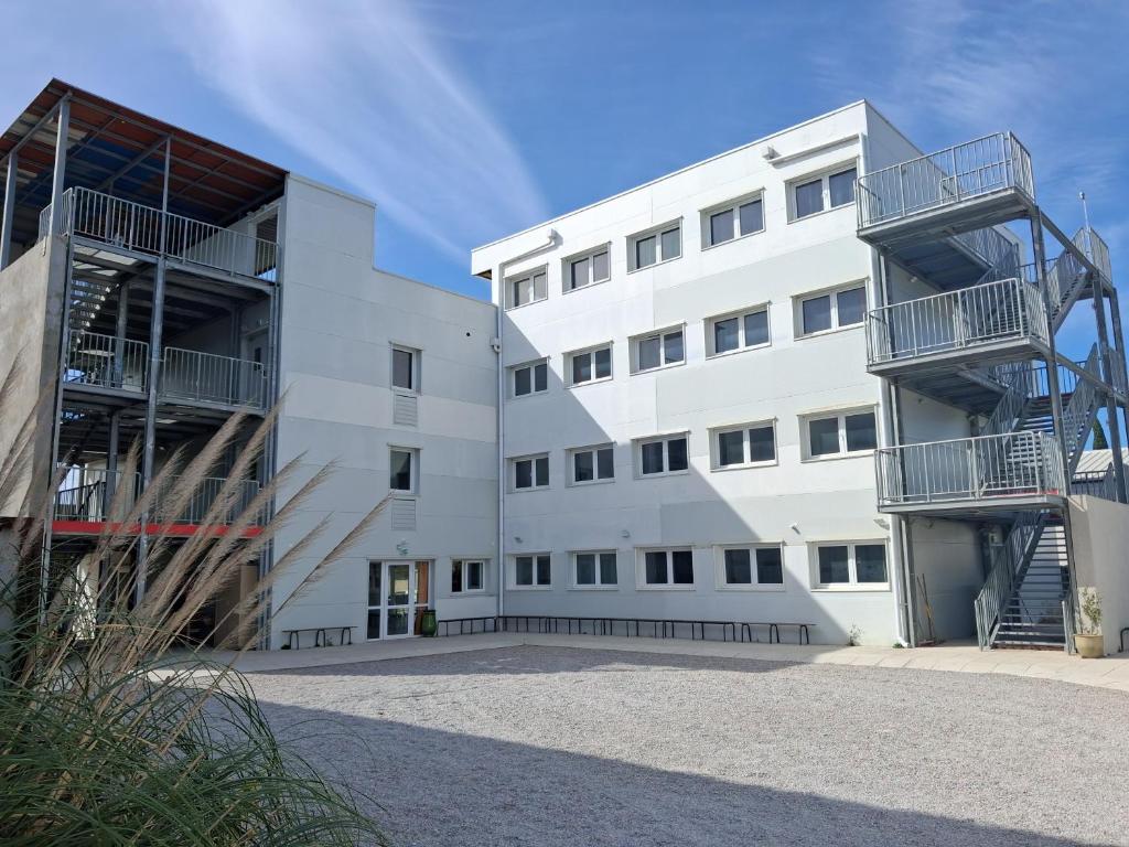a white building with two balconies on the side at Campus Arkenciel - Montpellier Est in Mudaison