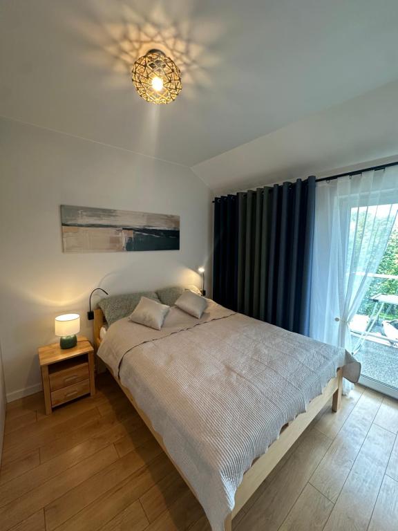 a bedroom with a large bed and a chandelier at Apartamenty Wichrowa in Żywiec