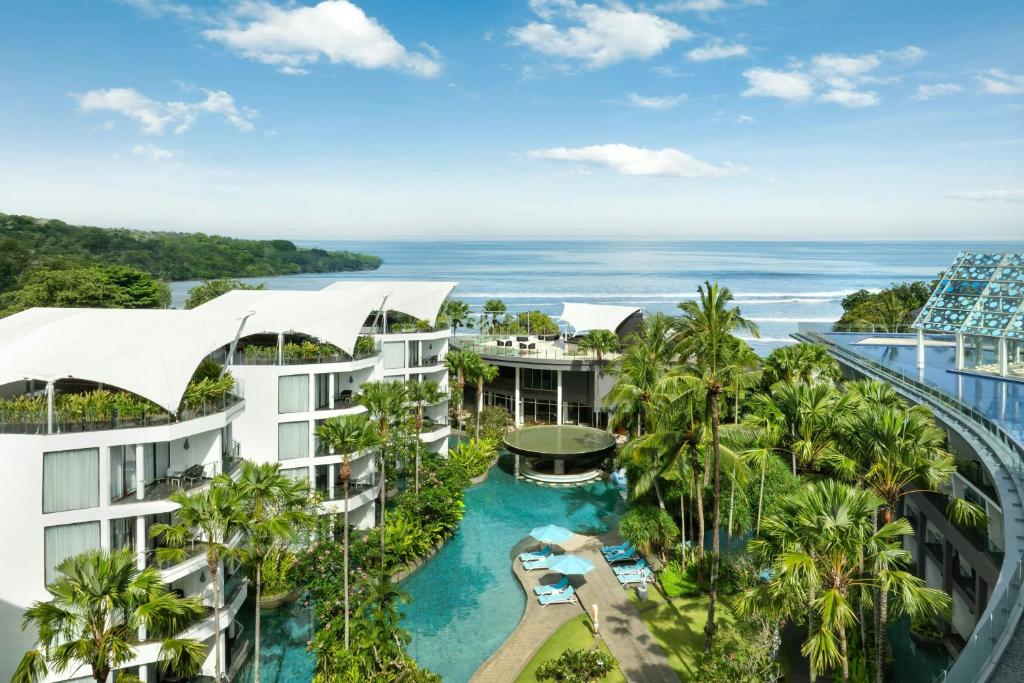an aerial view of a resort with a pool and the ocean at Le Meridien Bali Jimbaran in Jimbaran
