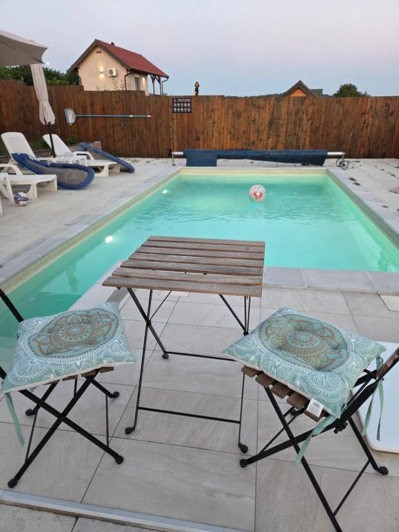 a table and two chairs next to a swimming pool at Avalska Bajka in Ripanj