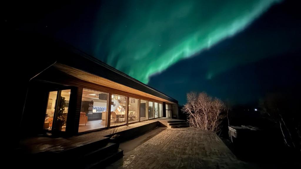 a building with a view of the aurora in the sky at Bergnes Lodge in Senja