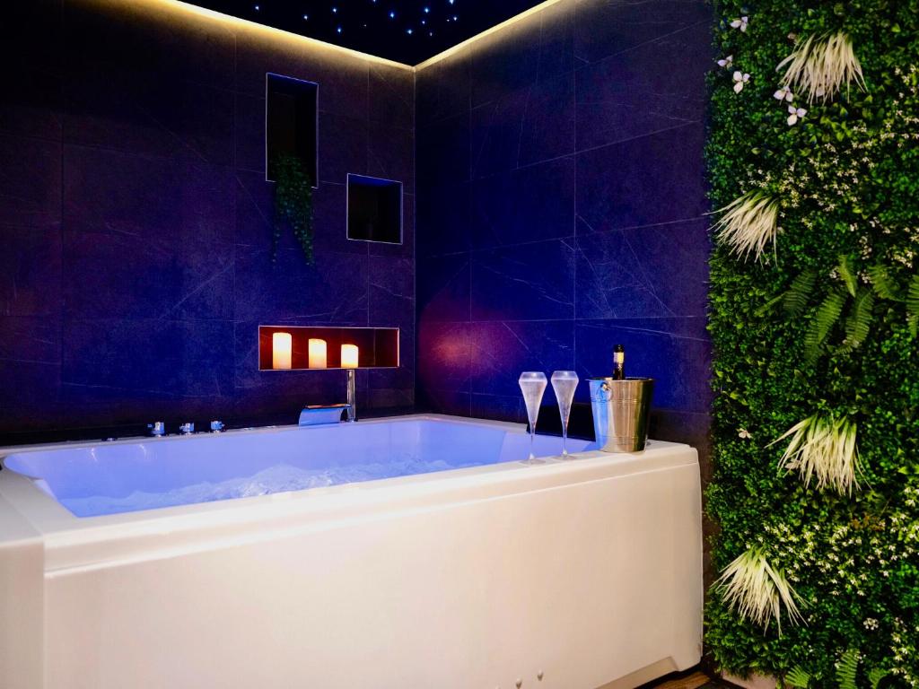 a bath tub in a bathroom with a green wall at Love Room Lorient - Le King Size - Balnéo 2 places in Lorient