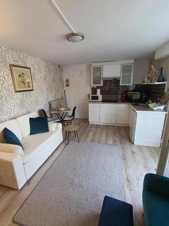 a living room with a white couch and a kitchen at The apartment in Saint-Rabier