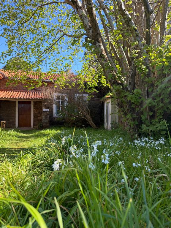 an old house with flowers in front of it at Casa Malde in Cedeira