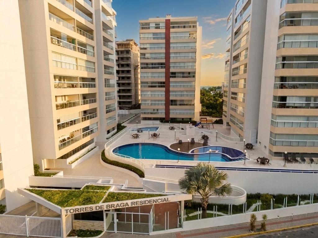 a view of a building with a swimming pool and buildings at Lar dos Santoprete I in Bertioga