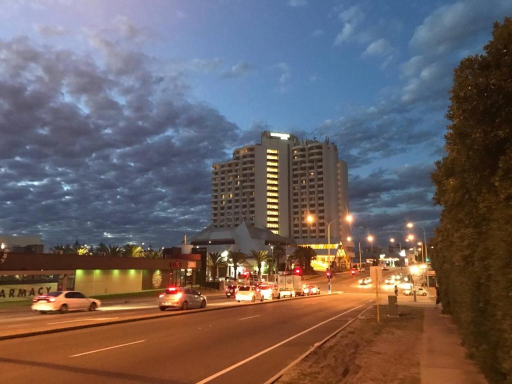 a city street at night with cars on the road at Scarborough Beach Shack in Perth