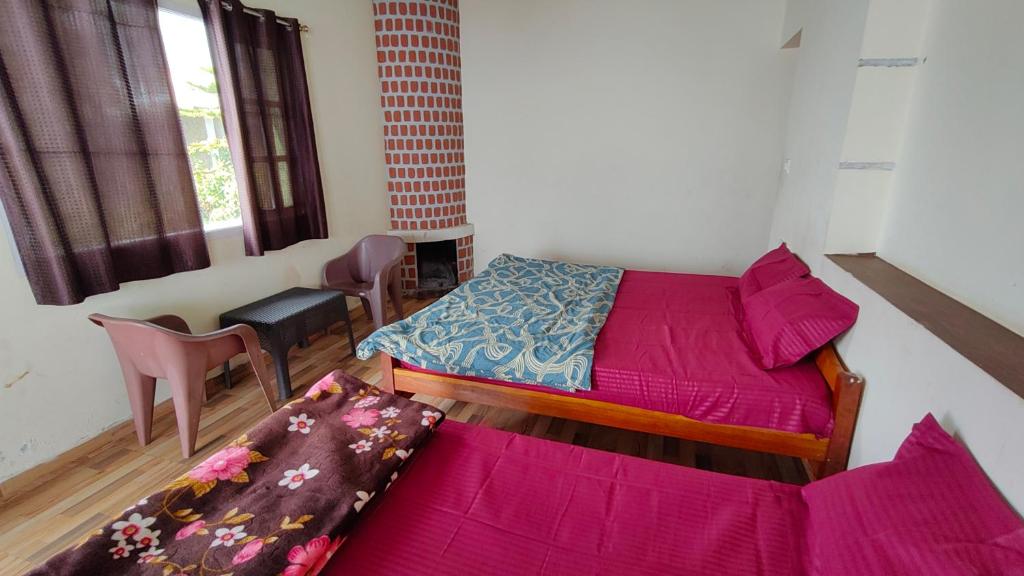 a bedroom with two beds and a couch in it at Emerald home stay in Kodaikānāl
