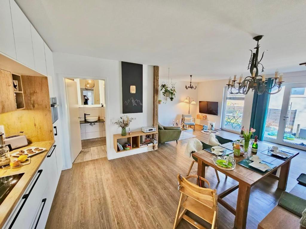 a kitchen and living room with a table and a dining room at LÜFTLE neue gemütliche große Familien Ferienwohnung im Allgäu nähe Bodensee in Wolfegg