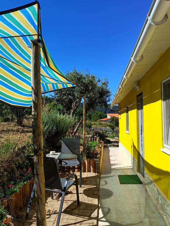 a patio with a table and an umbrella at Studio in Barbéns, Miranda do Corvo - Casa 99 in Miranda do Corvo