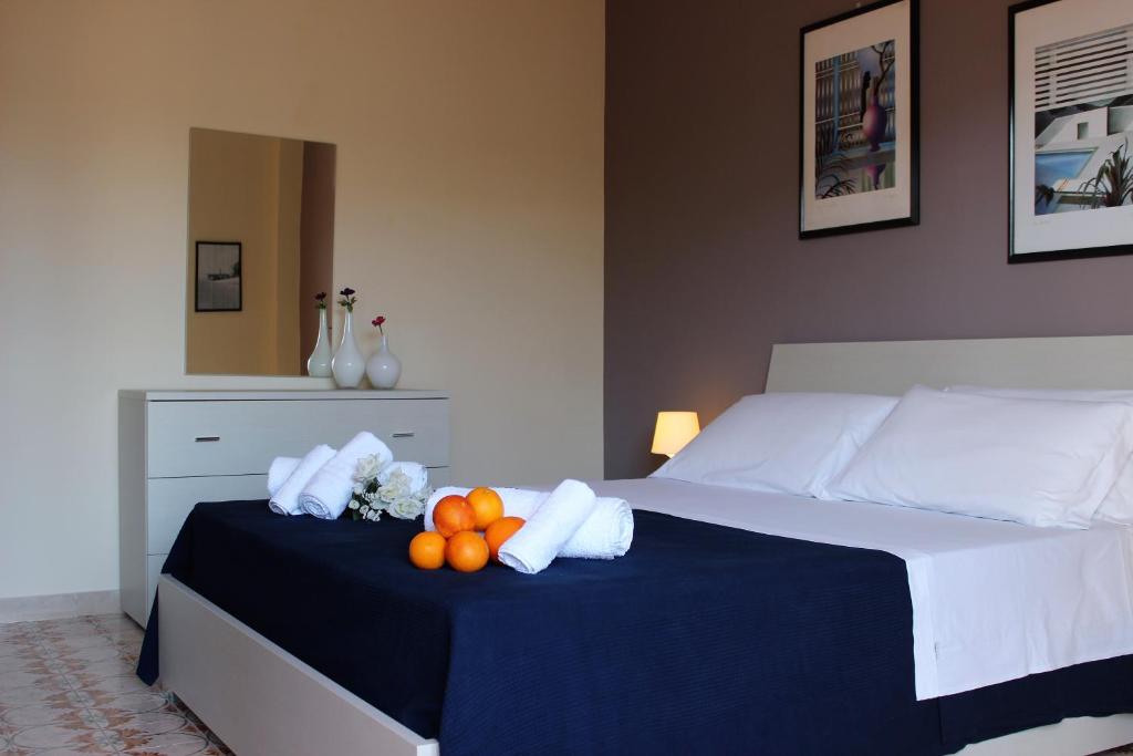 - une chambre avec un lit avec des oranges et des serviettes dans l'établissement Lucy Apartment, à Marina di Ragusa