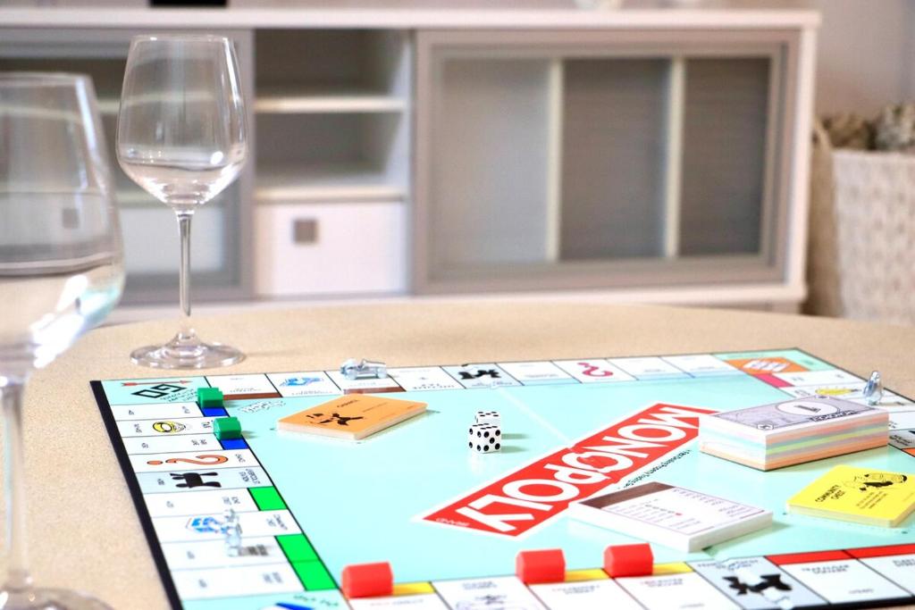 a table with a board game and two glasses of wine at The Olive Edit in Batemans Bay