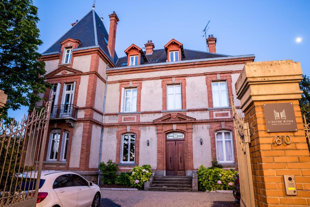 a house with a car parked in front of it at L'Autre Rives in Albi