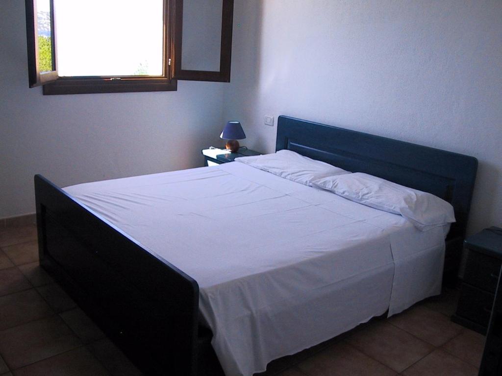 ラ・マッダレーナにあるAppartamento Scoglio Balenoのベッドルーム1室(大型ベッド1台、青いヘッドボード付)
