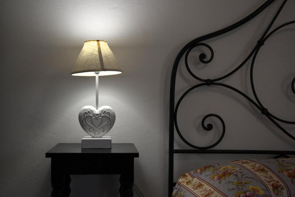 a lamp on a table next to a bed at Casa Rosa di Cavoli in Seccheto