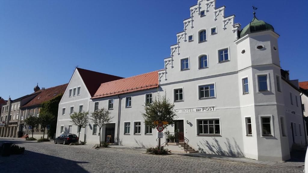 a large brick building with a clock tower at Boutique Hotel zur Post in Vohburg an der Donau