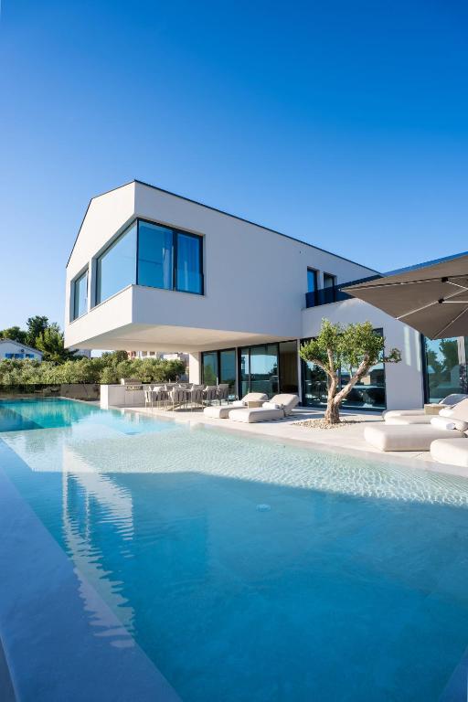 a house with a swimming pool in front of it at Villa FUX Eternity 3 in Ždrelac
