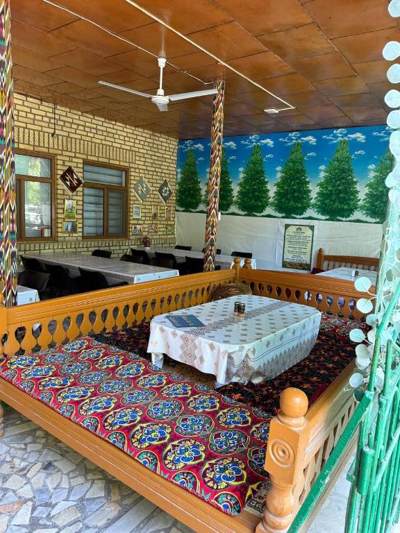 a large room with a table on a rug at Central Park Hostel in Khiva