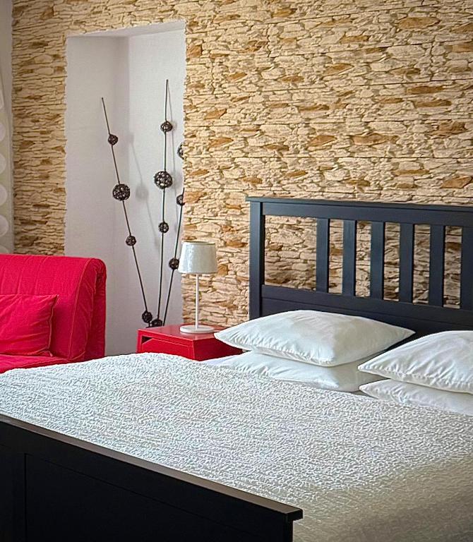 a bedroom with a bed and a stone wall at Apartments Centrum in Rožnov pod Radhoštěm