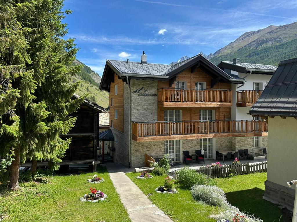 a large house with a balcony and a yard at Chalet Aeschhorn in Zermatt