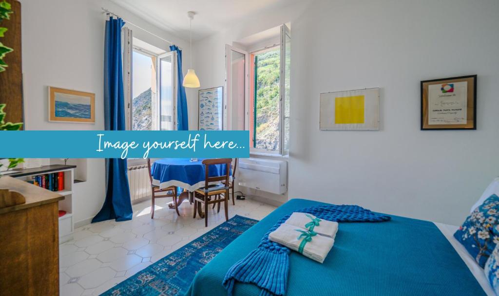 a bedroom with a bed and a table and chairs at Maemuna Sea View Apartment in Vernazza