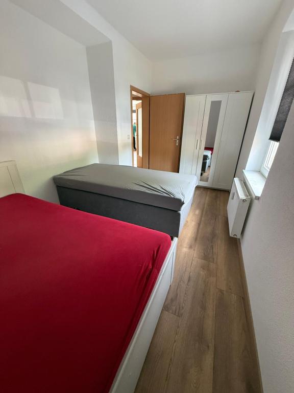 a bedroom with two beds and a red blanket at Cozy Room for 2 people in Dresden