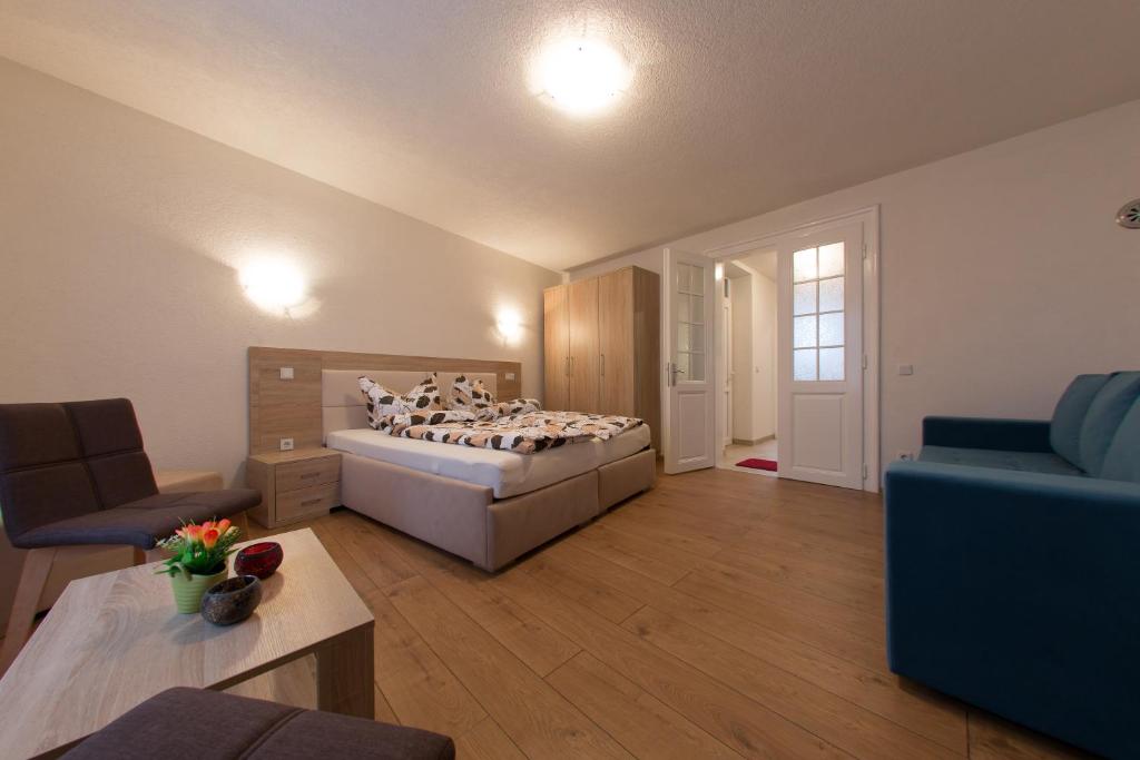 ein Schlafzimmer mit einem Bett und ein Wohnzimmer in der Unterkunft Apartment Sanny in Sarajevo