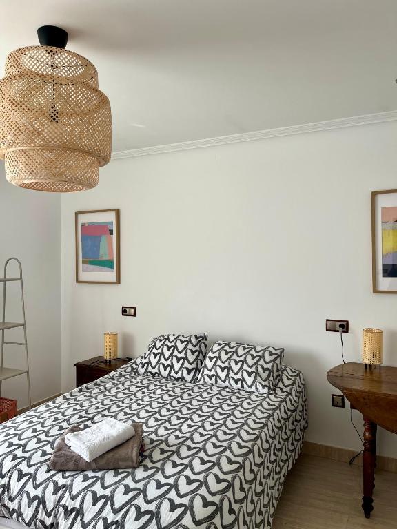 a bedroom with a black and white bed and a table at Casa María B - a 3km del Camino in Santa Eulalia