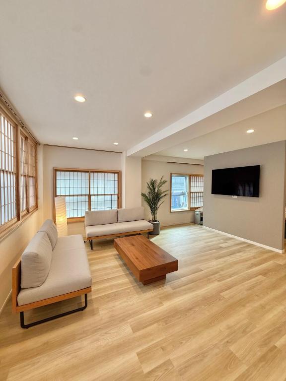 a living room with two couches and a flat screen tv at Central Roppongi House in Tokyo