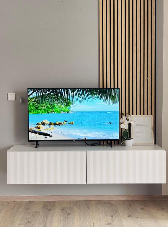 a flat screen tv sitting on top of a white cabinet at Apartman Sofija centar in Teslić