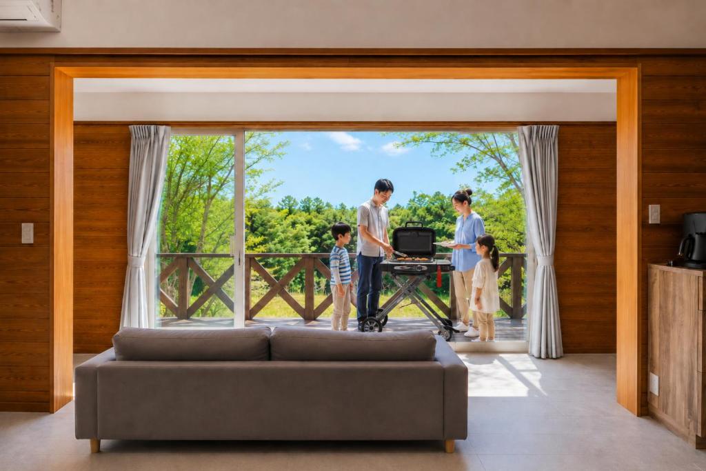 a family standing in a living room looking out the window at rinne 那須 Garden 3 in Nasu